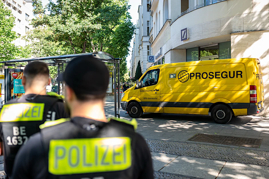 Polizisten stehen am Kurfürstendamm an einem Geldtransporter. Unbekannte hatten zuvor einen Überfall begonnen.