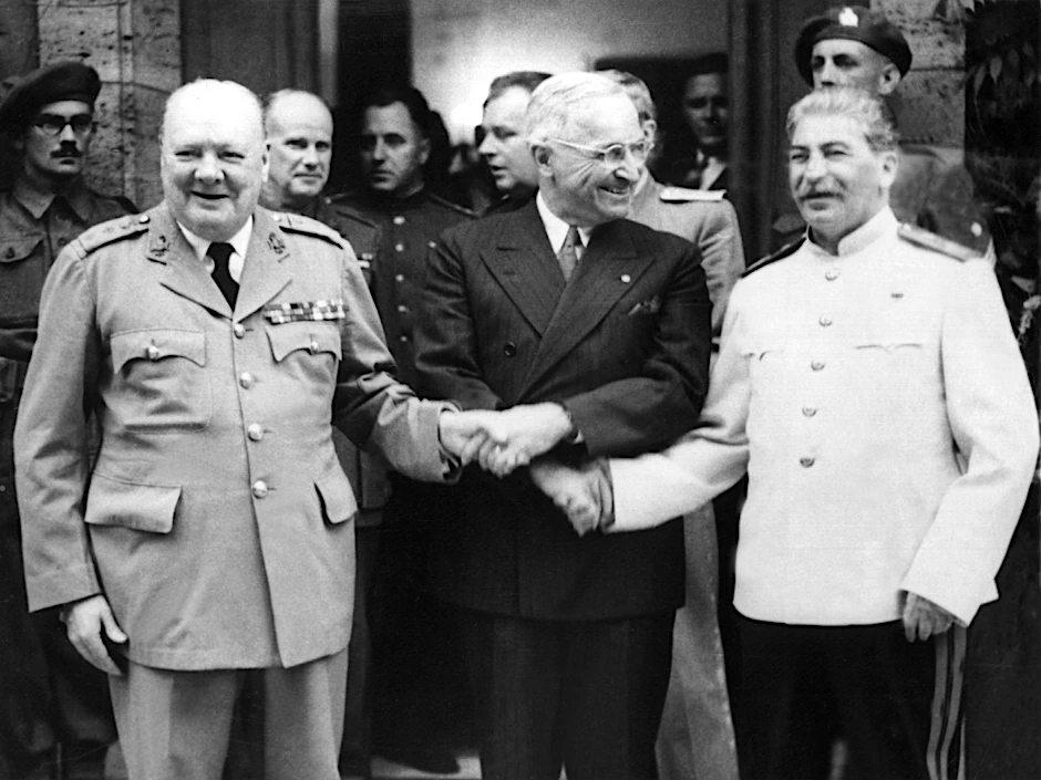 Trotz grundsätzlicher ideologischer Unterschiede redeten sie lösungsorientiert miteinander (v.l.n.r.): Der britische Premierminister Winston Churchill, der amerikanische Präsident Harry S. Truman und der sowjetische Diktator Josef Stalin reicht Staats- und Parteichef en sich während der Potsdamer Konferenz vor Schloss Cecilienhof die Hände.