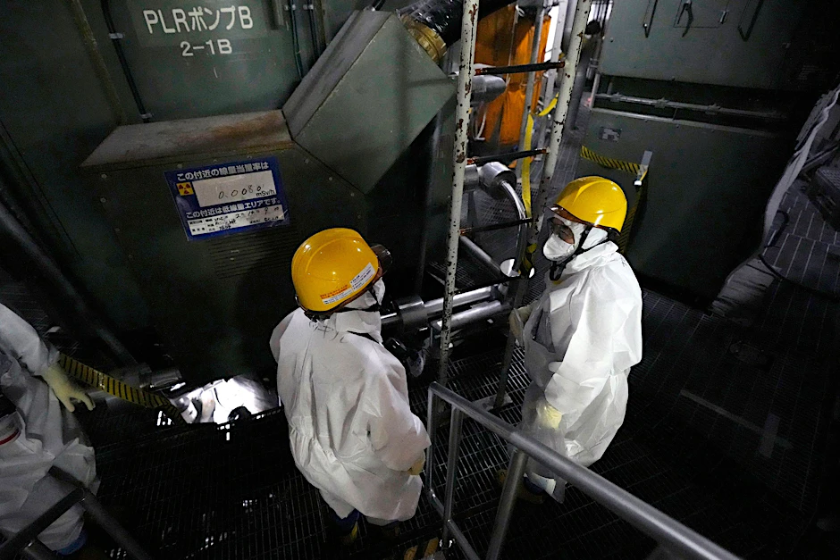 Mitarbeiter der Tokyo Electric Power Company Holdings führen Journalisten zum Reaktordruckbehälter von Block 5 im Kernkraftwerk Fukushima.