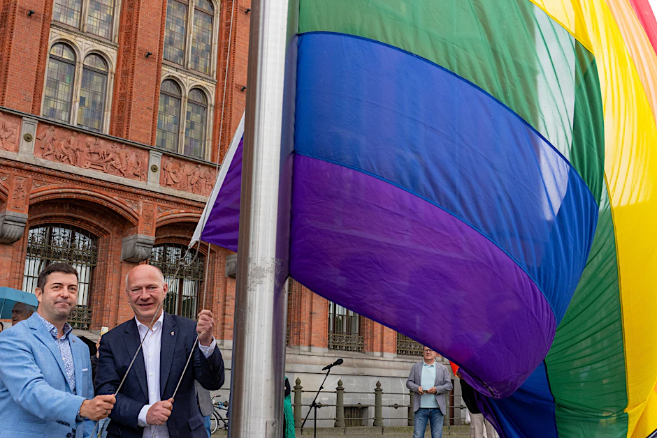 Kai Wegner und Florian Winkler-Schwarz (l.) vom Lesben- und Schwulenverband ziehen vor dem Roten Rathaus die Regenbogenflagge auf.