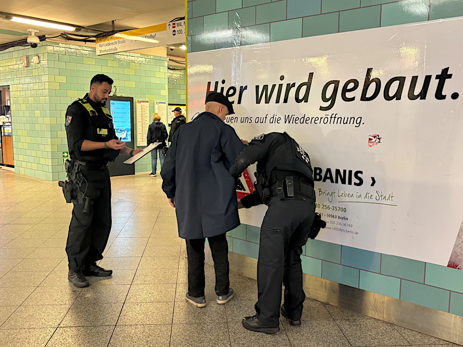 Im U-Bahnhof Alexanderplatz durchsuchen Polizisten einen Reisenden.