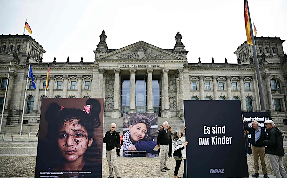 Überlebensgroße Tafeln mit Porträts von Kindern aus Gaza stehen im Rahmen der Protest-Installation „Den Kindern Gazas in die Augen schauen“ vor dem Reichstag.