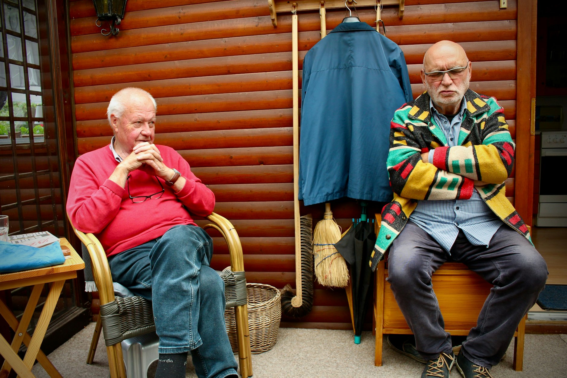 Claus Rainer Ernst (l) und Walter Meier (r) sitzen unter dem Vordach der Laube 56, der Regen prasselt. Sie teilen die Sorge, dass die Lauben von Breitehorn bald abgerissen werden müssen.