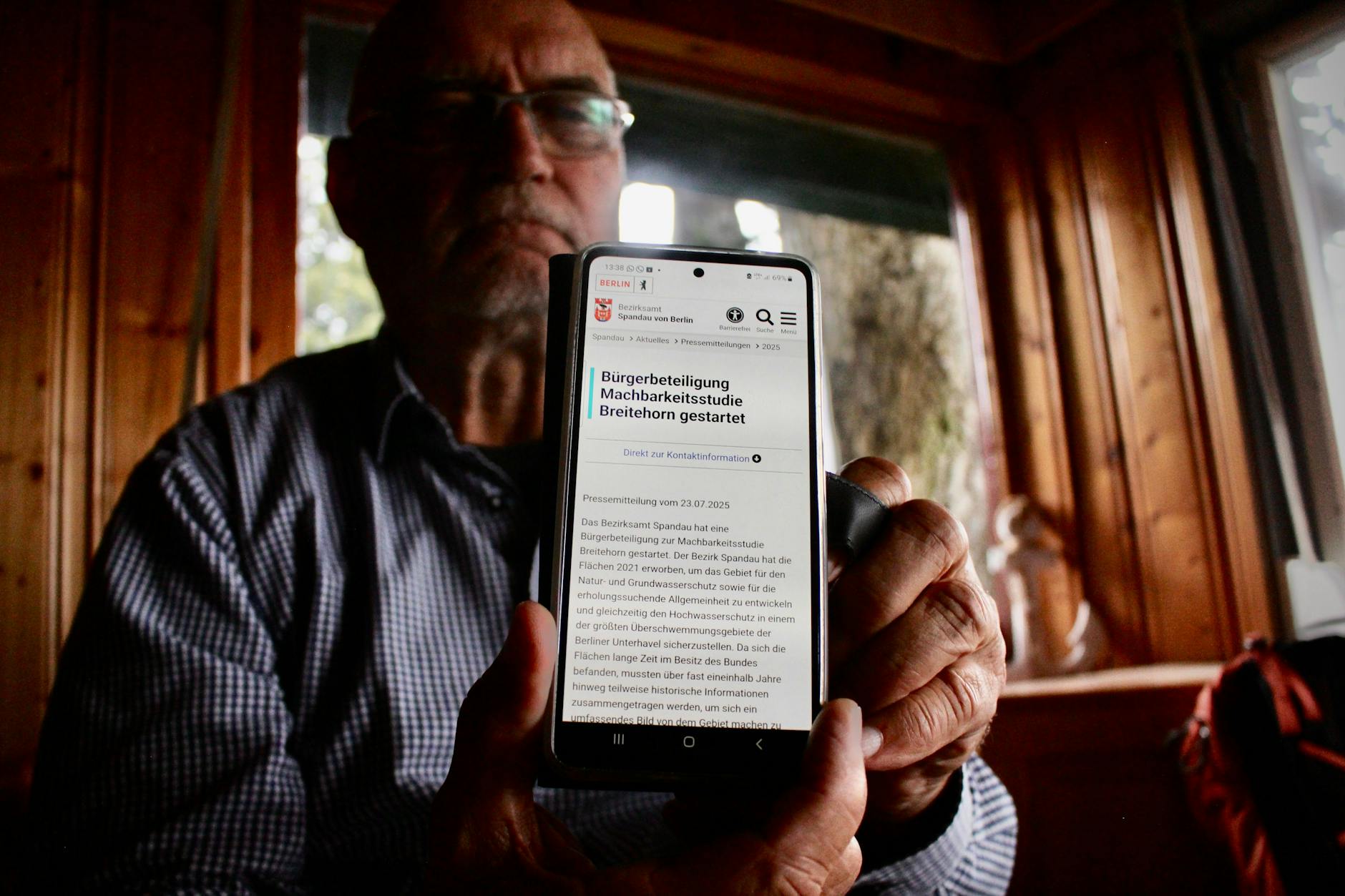 Seit Ende 2021 gehört das Gelände am Breitehorn dem Land Berlin. Geplant ist ein Rückbau großer Teile der Siedlung. Es geht um Grundwasserschutz, Renaturierung und öffentliche Erholungsnutzung. Nur wenige Lauben sollen bestehen bleiben. Walter Meier zeigt eine Mitteilung über die Bürgerbeteiligung an dem Vorhaben. Er erklärt: „Hier können wir noch was sagen, unter breitehorn@ba-spandau.berlin.de bis zum 20. August.“