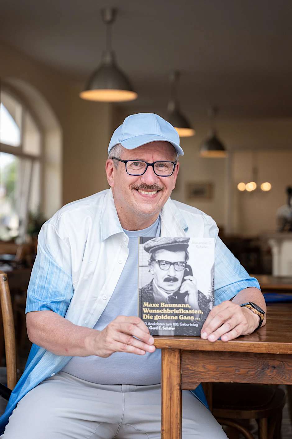 Die Ähnlichkeit ist verblüffend: Alexander G. Schäfer mit seinem Buch über seinen Vater Gerd E. Schäfer, der vor fast 50 Jahren das erste Mal die Rolle von Maxe Baumann spielte.