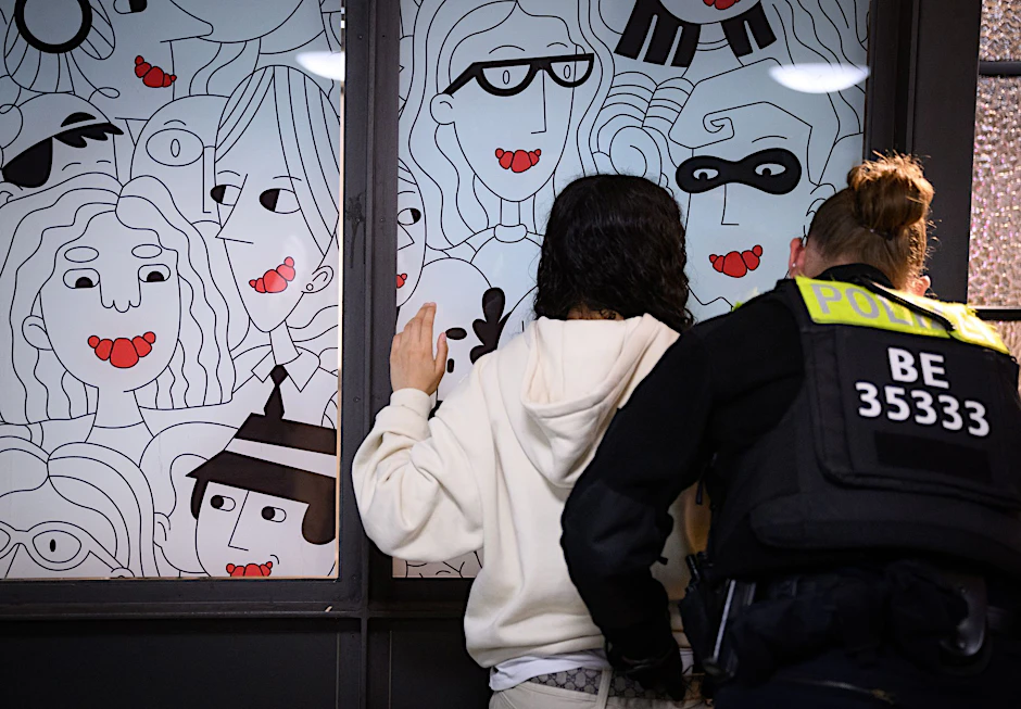 Eine Polizeibeamtin durchsucht am Bahnhof Alexanderplatz zu Beginn des Waffenverbots in Berliner U-Bahnen eine junge Frau.