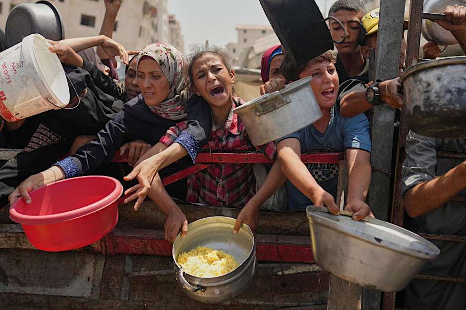 Palästinenser kämpfen um gespendete Lebensmittel in einer Gemeinschaftsküche im nördlichen Gazastreifen.