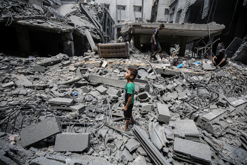 Ein palästinensisches Kind steht inmitten der Trümmer nach einem israelischen Morgenangriff auf ein Haus.