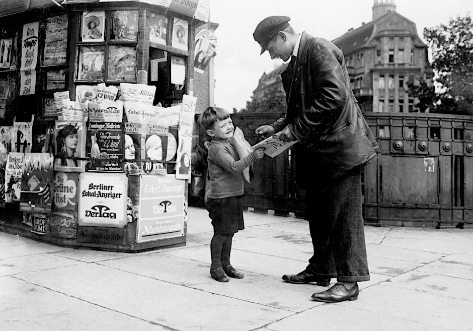 In den Jahren der Weimarer Republik blühte die Zeitungs- und Zeitschriftenlandschaft Deutschlands: Ein kleiner Junge verkauft 1930 eine Zeitung an einen Passanten in Berlin.