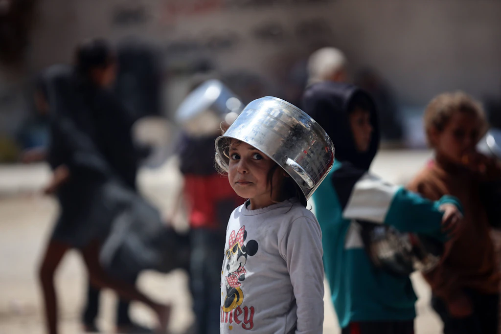 Ein Kind wartet in Gaza-Stadt an einer Essensausgabe.