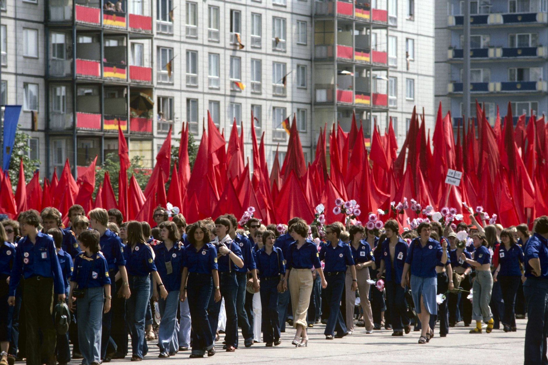 FDJler mit riesigen roten Fahnen beim Aufmarsch auf der Karl-Marx-Allee am 3. Juni 1979.