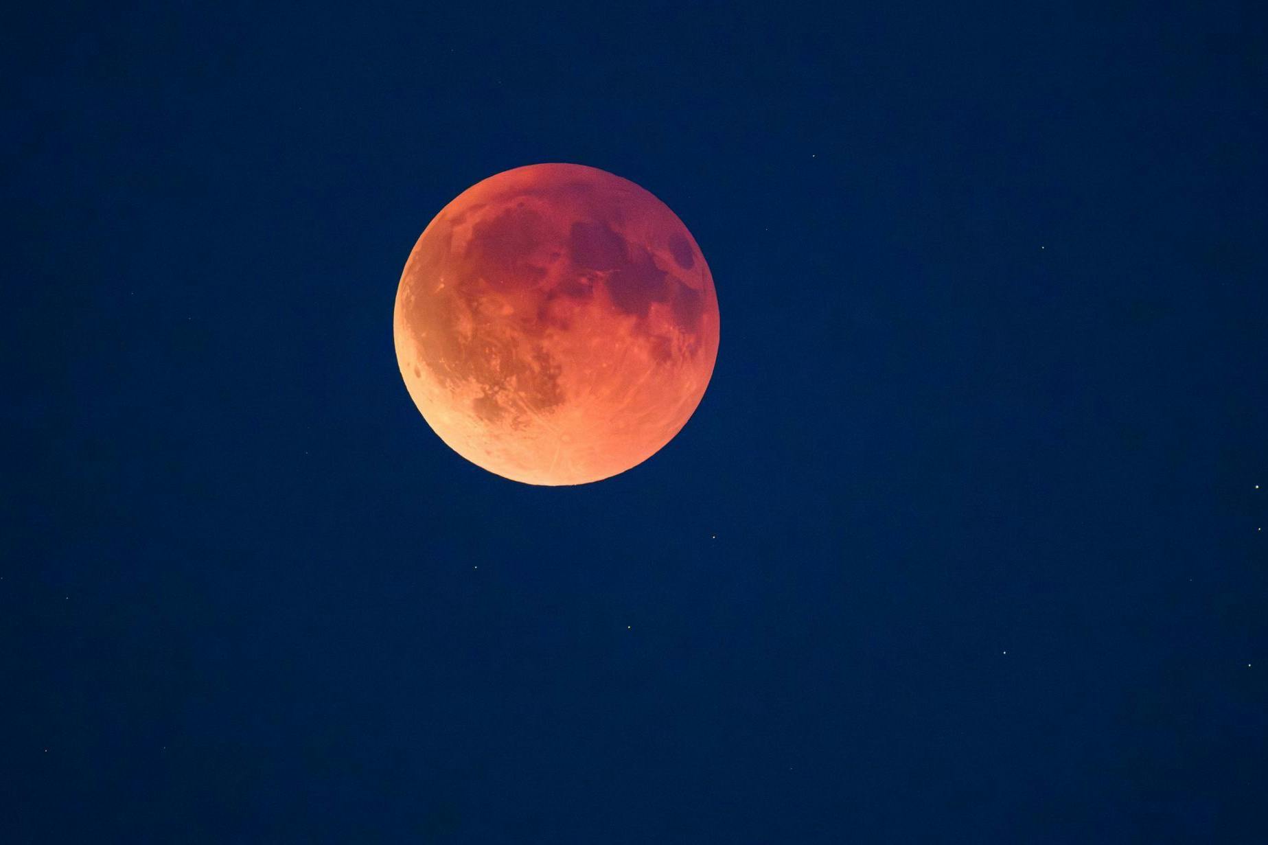 Der Mond verfärbt sich im Schatten der Erde rot, weshalb man das Schauspiel auch als Blutmond bezeichnet.