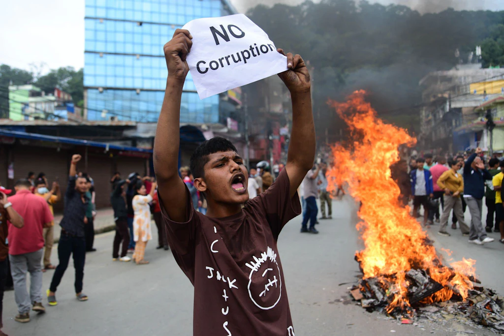 Ein Demonstrant in Nepal hält einen Zettel hoch, auf dem „Keine Korruption"&nbsp;steht.