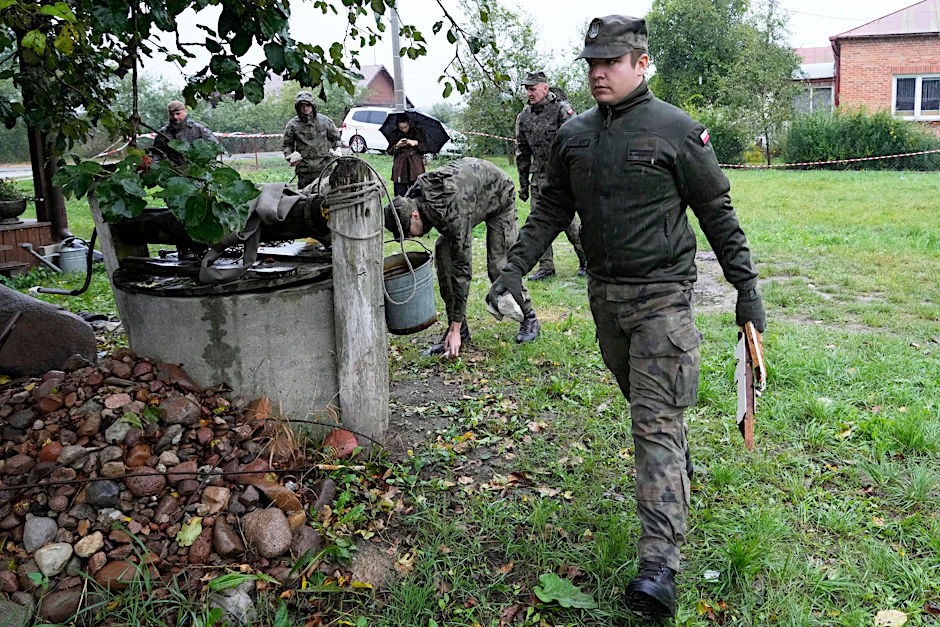 Beamte der Territorialen Verteidigung räumen Trümmer vom zerstörten Dach eines Hauses auf, nachdem Drohnen den polnischen Luftraum verletzt haben sollen.