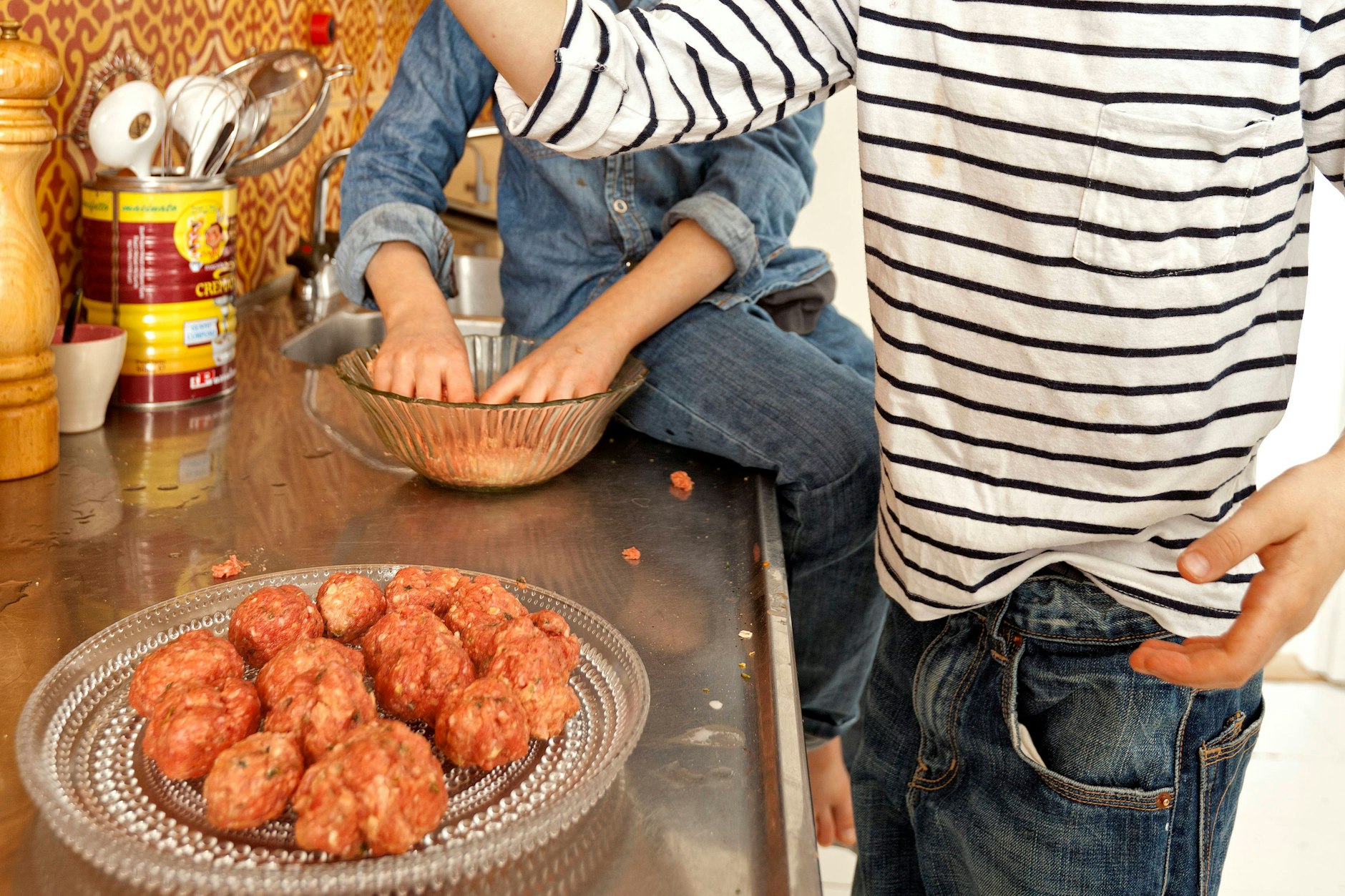 Wenn sich die Köttbullar beim Formen schlecht rollen lassen oder die Masse an den Händen klebt, stellen Sie einfach ein kleines Schälchen mit kaltem Wasser bereit. Tauchen Sie die Hände kurz hinein, dann gleitet der Teig besser und die Bällchen werden schön rund.
