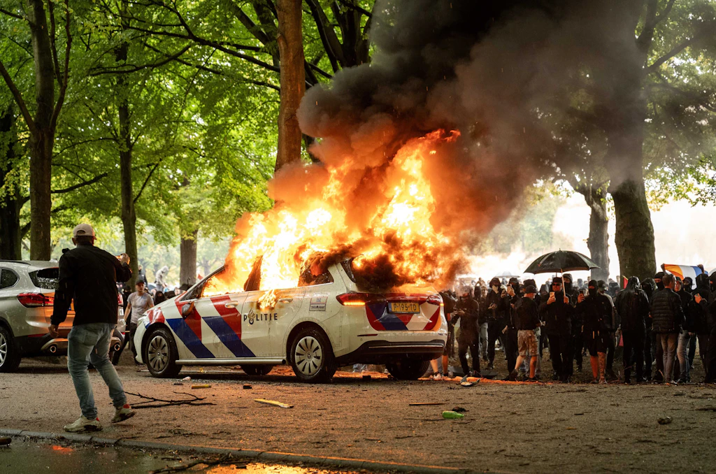 Anti-immigration protests escalate in The Hague: Police car set on fire ...