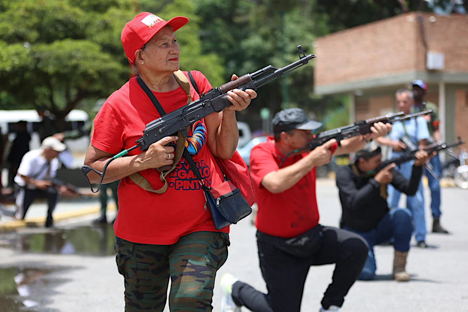 Mitglieder der Gemeinde- und Zivilräte halten Gewehre während eines militärischen Waffentrainings in Fort Tiuna in Caracas.