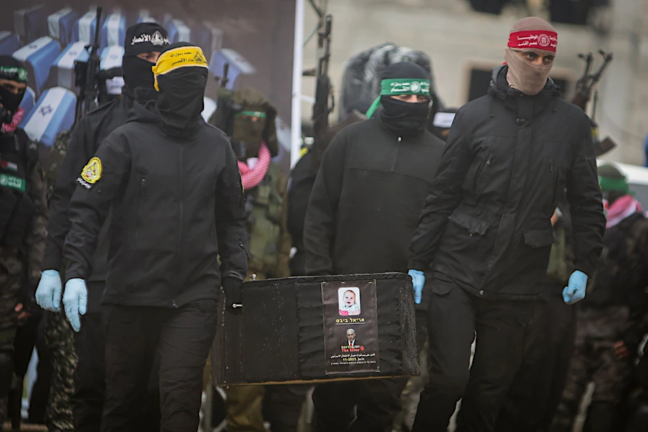 Hamas-Terroristen übergeben den Sarg von Kfir Bibas (zehn Monate alt), der jüngsten israelischen Geisel, an das Rote Kreuz.