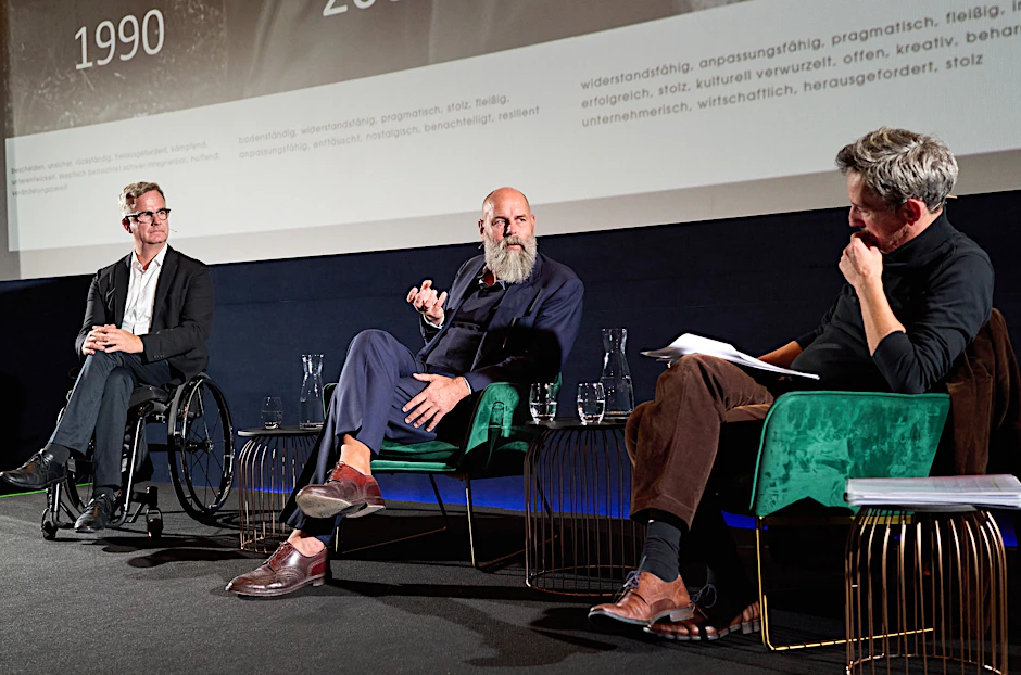 Verleger Holger Friedrich (M) und der Filmproduzent Olaf Jacobs (L) im Gespräch und Moderator Peter Effenberg.