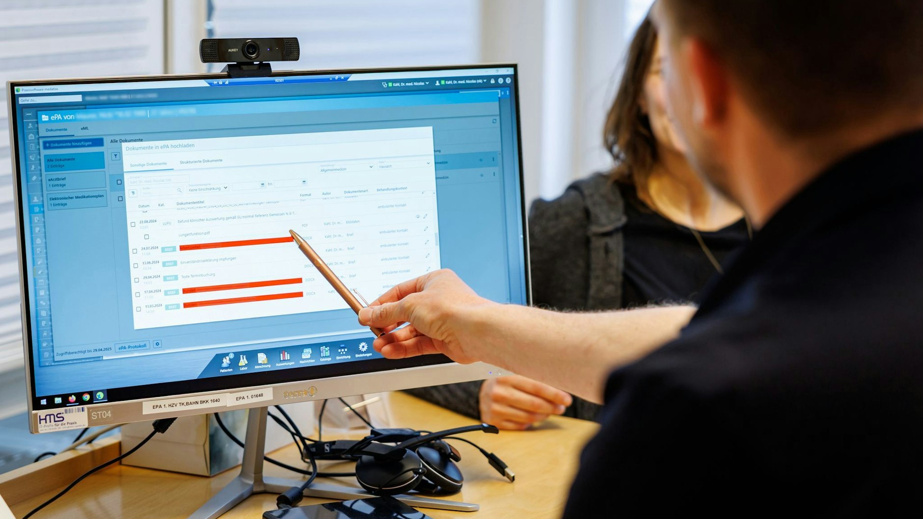 Ein Hausarzt lädt in seiner Praxis Dokumente in eine elektronische Patientenakte.