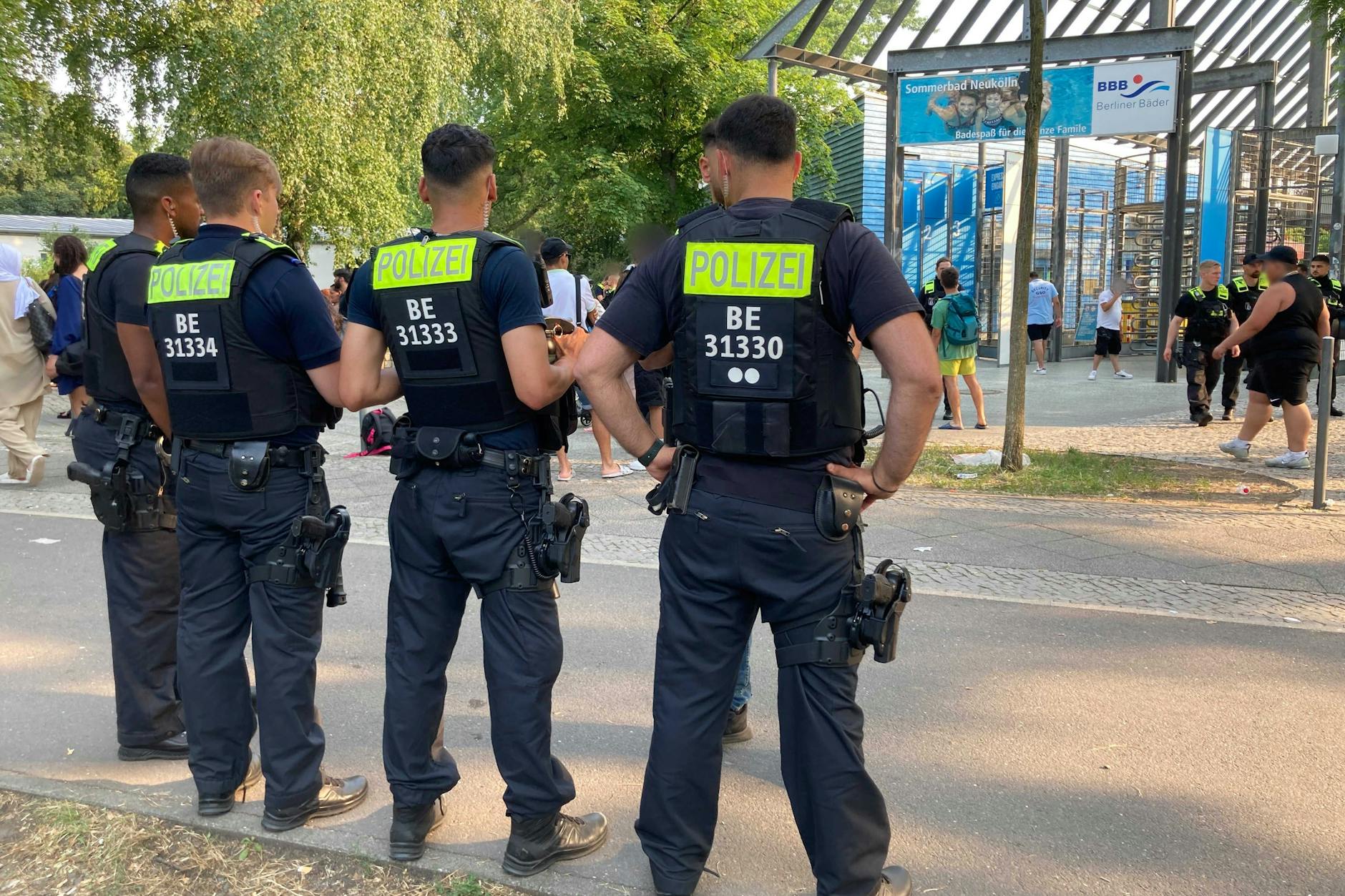 Polizisten stehen vor dem Eingang des Sommerbades in Neukölln. Die Polizei hat in der zurückliegenden Freibadsaison rund 180 Straftaten erfasst.