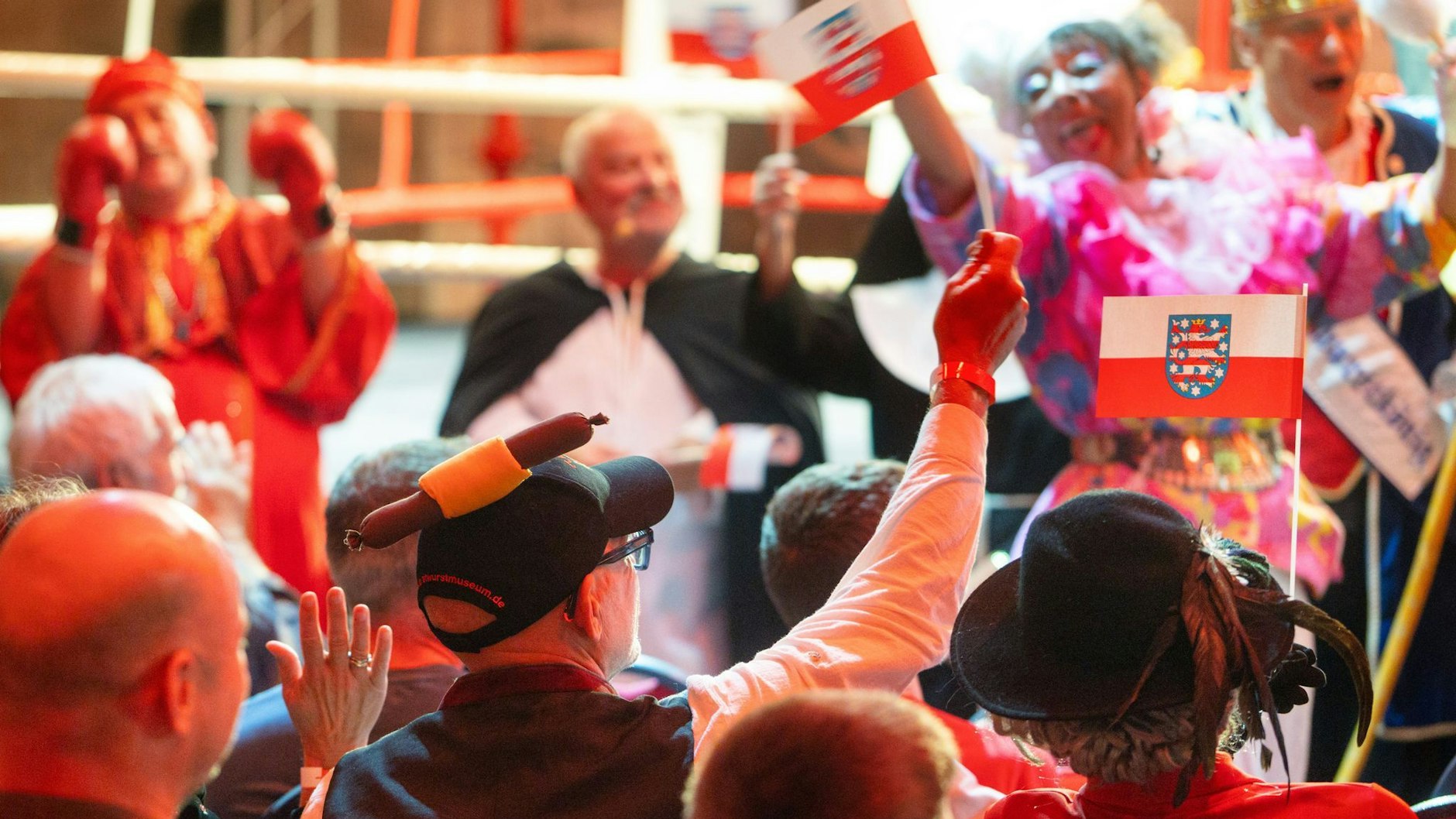 Zuschauer jubeln vor einem Boxring im Bratwurstmuseum vor dem Boxkampf im Bratwurststreit.