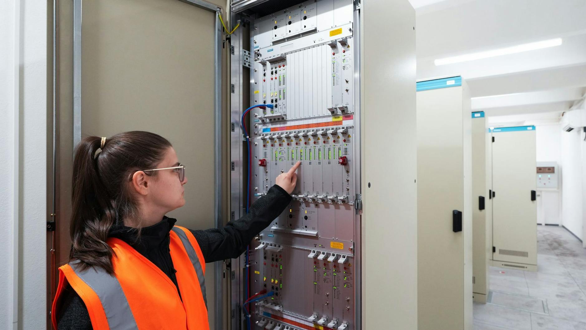 Die BVG-Mitarbeiterin Yasmin Große (Signalmechanikerin) steht in dem künftigen digitalen U-Bahn-Stellwerk am Alexanderplatz vor einer Signalbaukarte.
