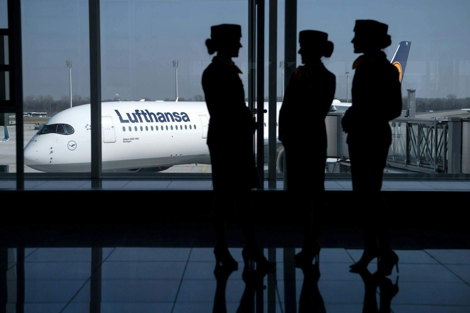 Flugbegleiterinnen der Deutschen Lufthansa AG stehen am Flughafen in München.