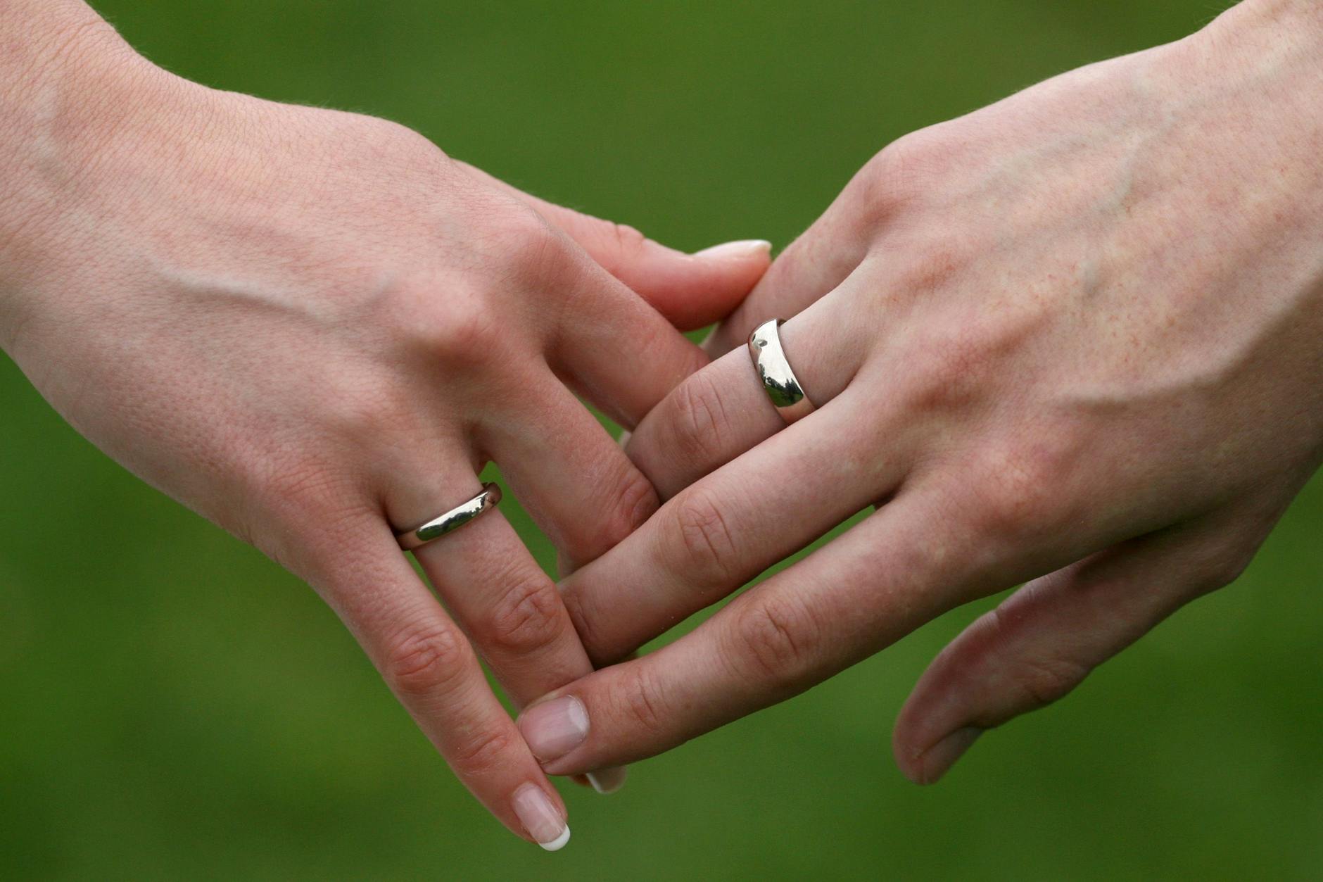 Ein frisch getrautes Brautpaar hält sich die Hände.