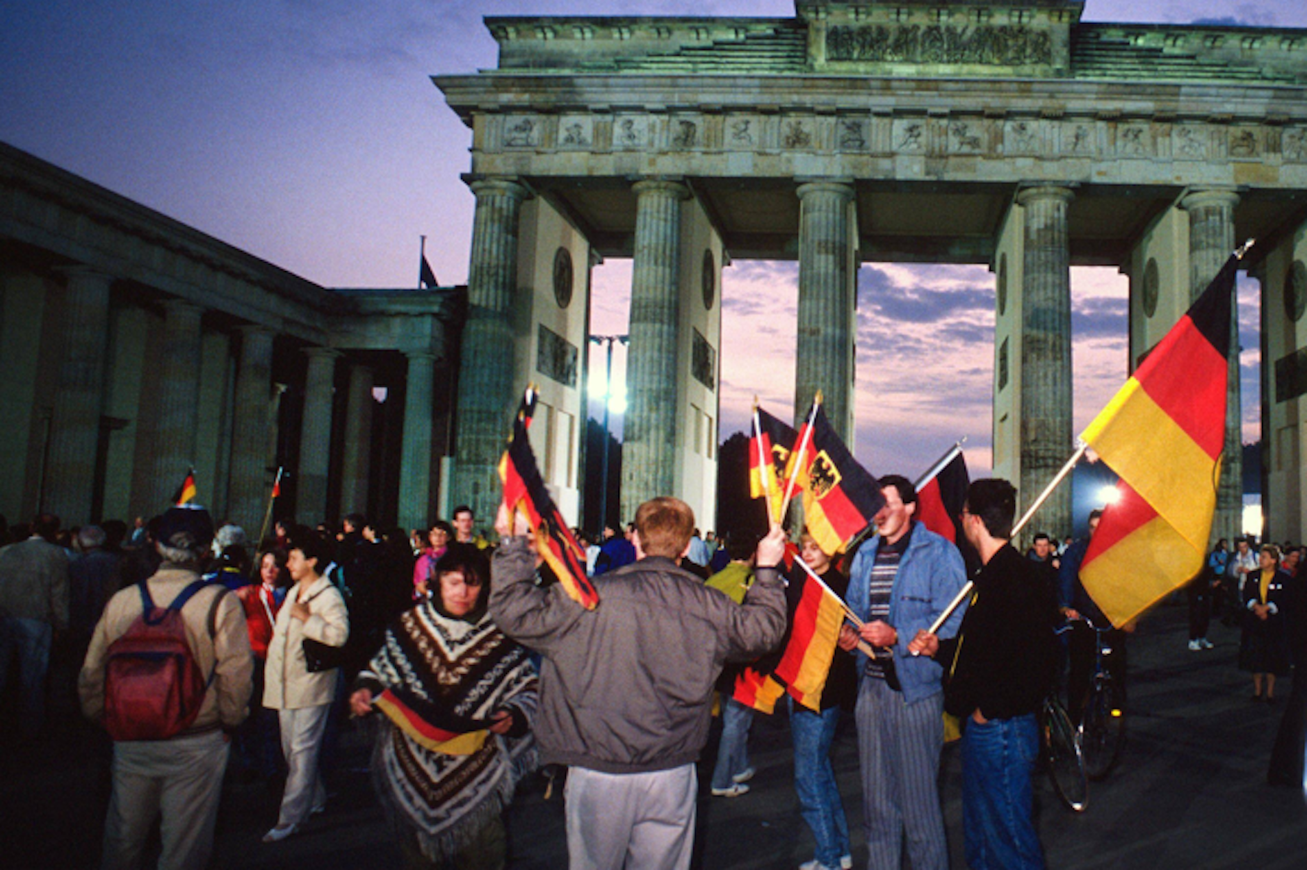Menschen versammeln sich am 3. Oktober 1990 am Brandenburger Tor, um die deutsche Einheit zu feiern.