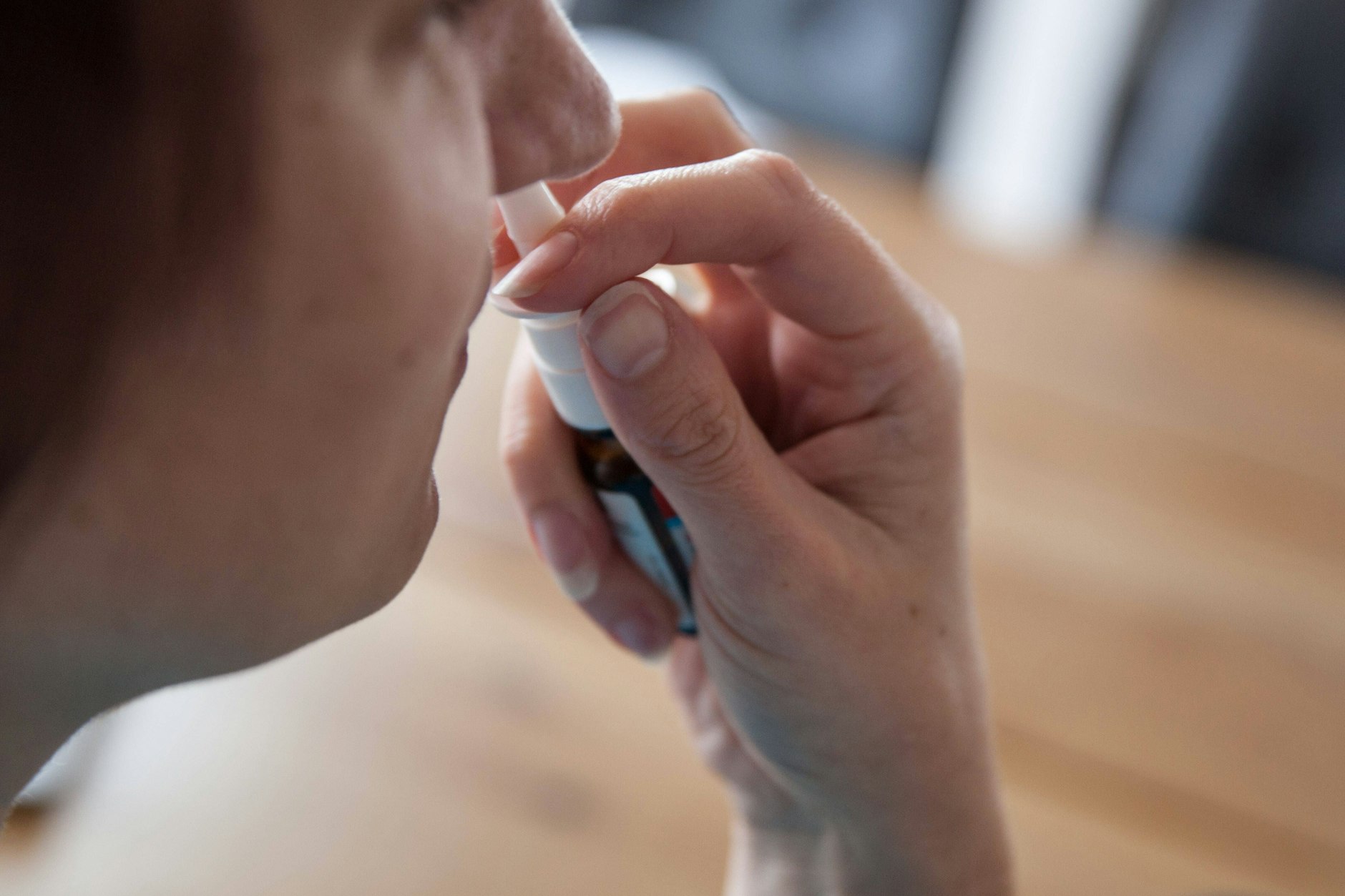 Eine Frau benutzt ein Nasenspray.