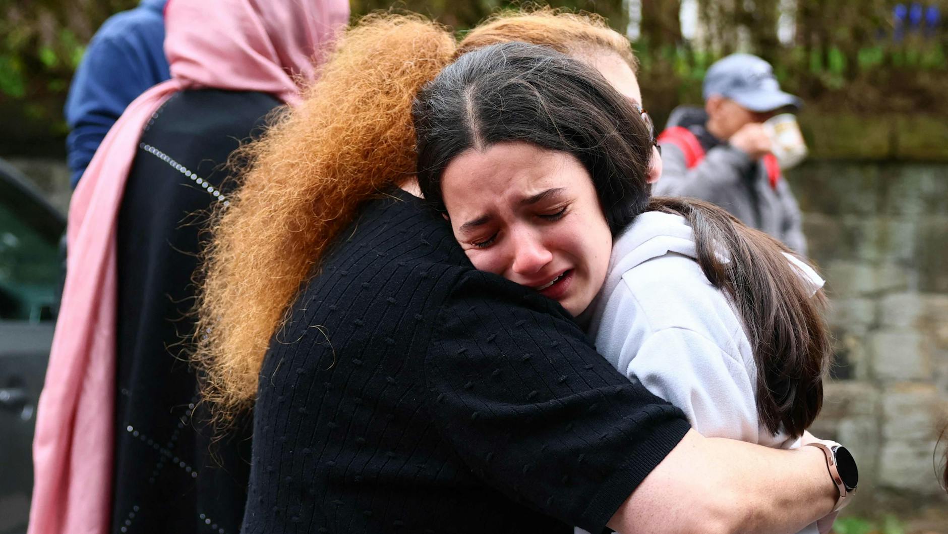 Mitglieder der Gemeinde stehen unter Schock und spenden einander Trost.