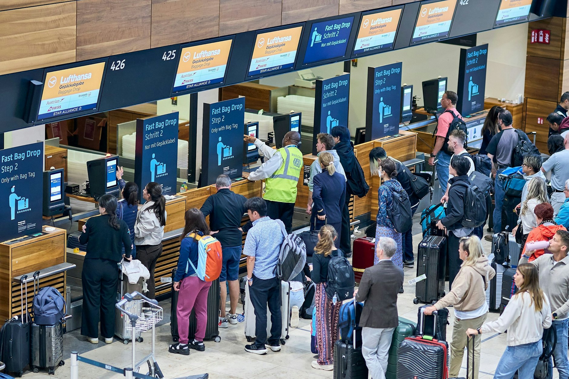 Zahlreiche Fluggäste warten vor den Check-in-Schaltern im Terminal 1 des Flughafens Berlin Brandenburg.