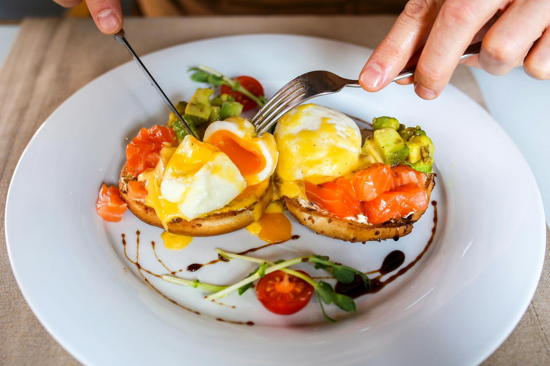 Beim Frühstücks-Klassiker Eggs Benedict werden pochierte Eier mit Toast, Schinken und Sauce hollandaise gegessen.