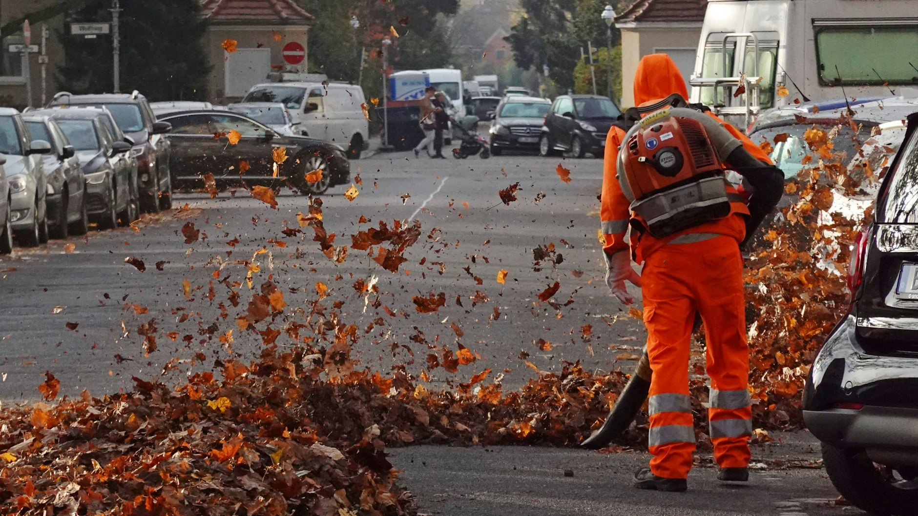 Ein Mitarbeiter der Berliner Stadtreinigung (BSR) befreit eine Straße vom Herbstlaub.