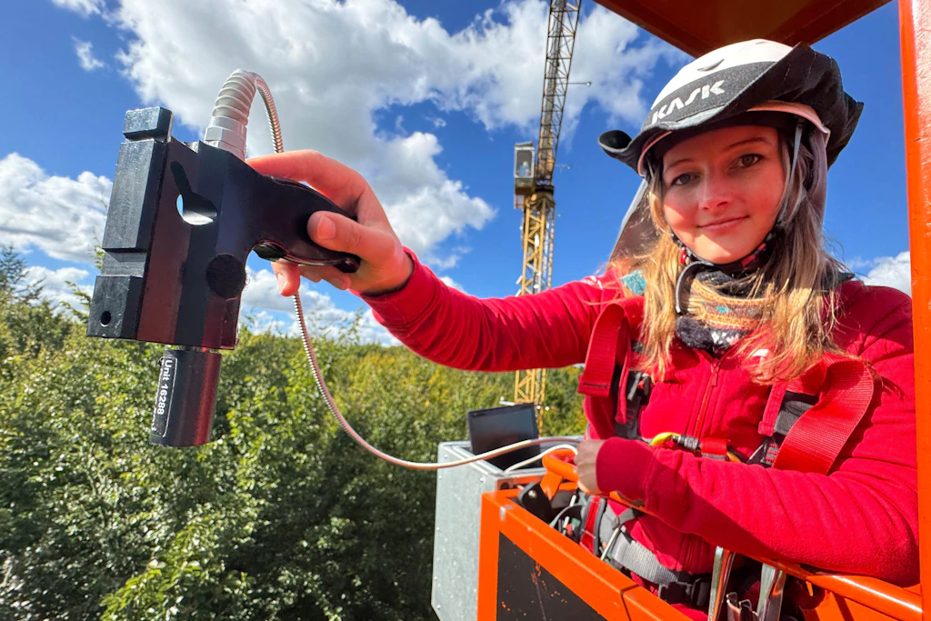Pia Kräft von der Technischen Universität Berlin führt von ihrer Krangondel aus eine Messung der Sonnenreflektion der Blätter durch.