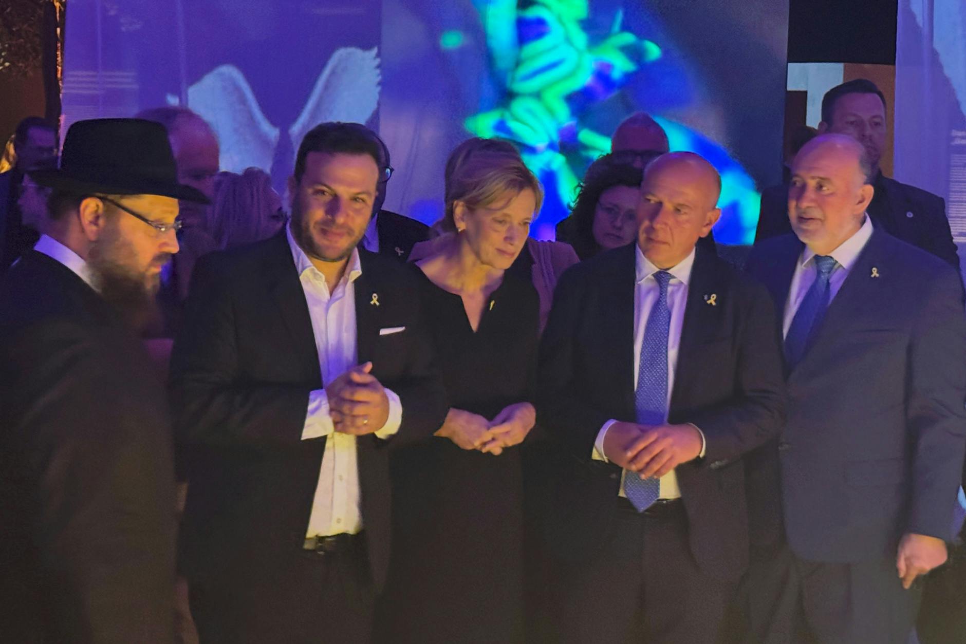 Festival-Organisator und Überlebender Ofir Amir (2.v.l.) und Rabbiner Yehuda Teichtal (l.) eröffnen die Nova-Austellung im Flughafen Tempelhof. Der Regierende Bürgermeister Kai Wegner (2.v.r.) hielt ebenfalls eine Rede.