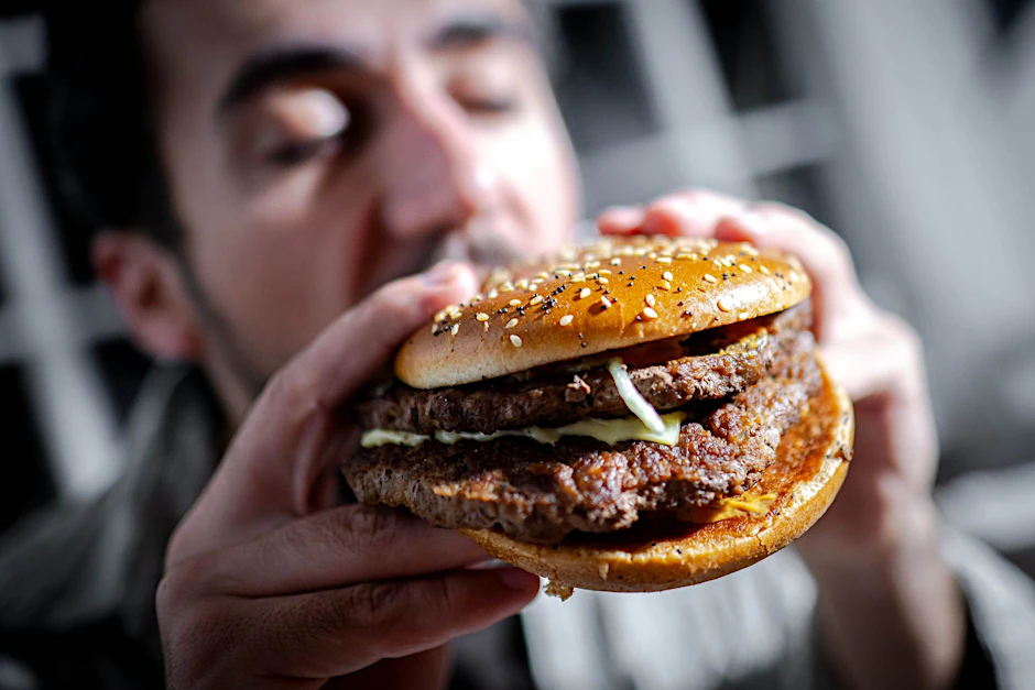 Ein Mann beißt in einen Burger.