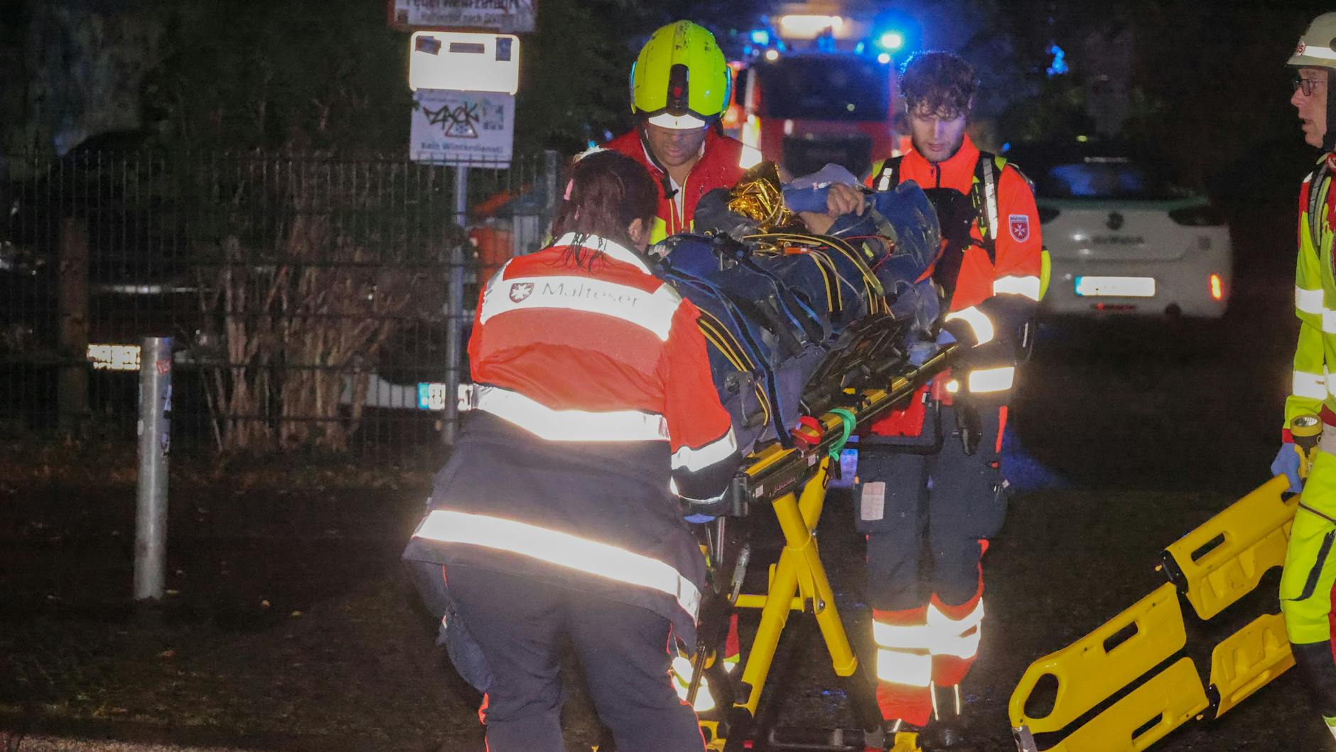 Nach der Erstversorgung auf dem Dach bringen Rettungskräfte und Notarzt den schwer verletzten Mann in ein Krankenhaus.