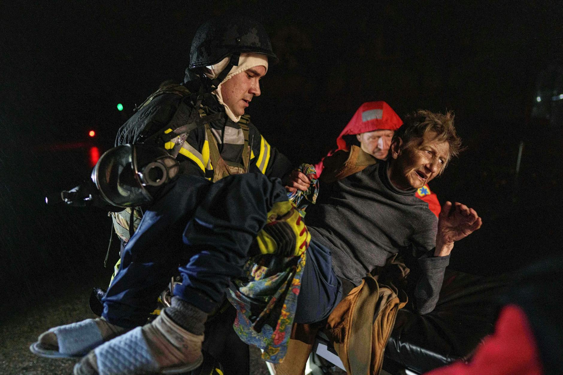 Kiew: Retter tragen eine verletzte Frau in einen Krankenwagen nach einem russischen Angriff auf ein Wohnviertel.