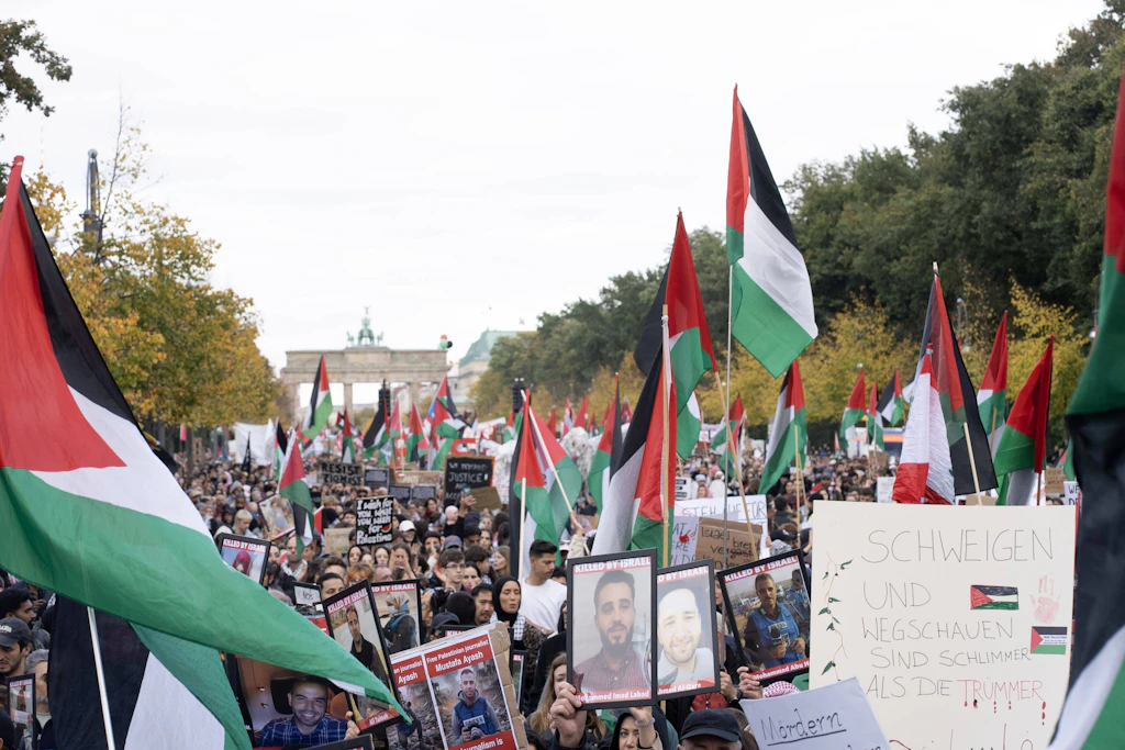 Zahlreiche Menschen nehmen an der pro-palästinensischen und anti-israelischen Demonstration teil. Im Hintergrund ist das Brandenburger Tor zu sehen.