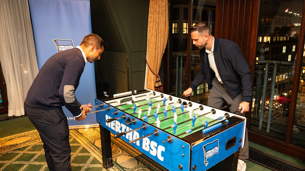 Sami Allagui (l.), Sportkoordinator von Hertha BSC, und Torwart Marius Gersbeck spielen sich am Tischkicker für die Duelle mit den Gästen im Berlin Capital Club warm.