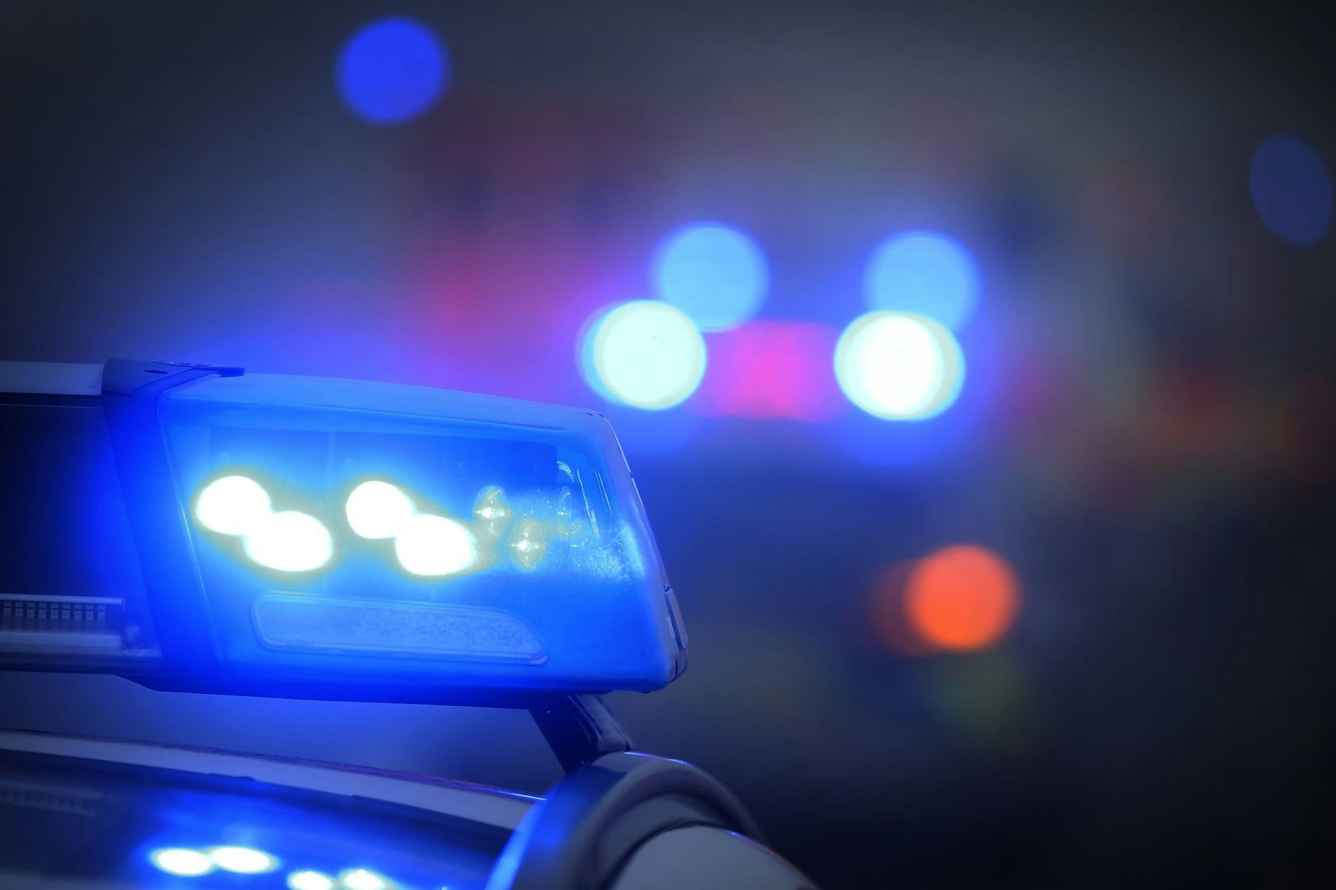 Ein Polizeiauto mit eingeschaltetem Blaulicht steht an einer Unfallstelle. (zu dpa: «Protestgruppen zünden Pyrotechnik in Berlin-Kreuzberg»)