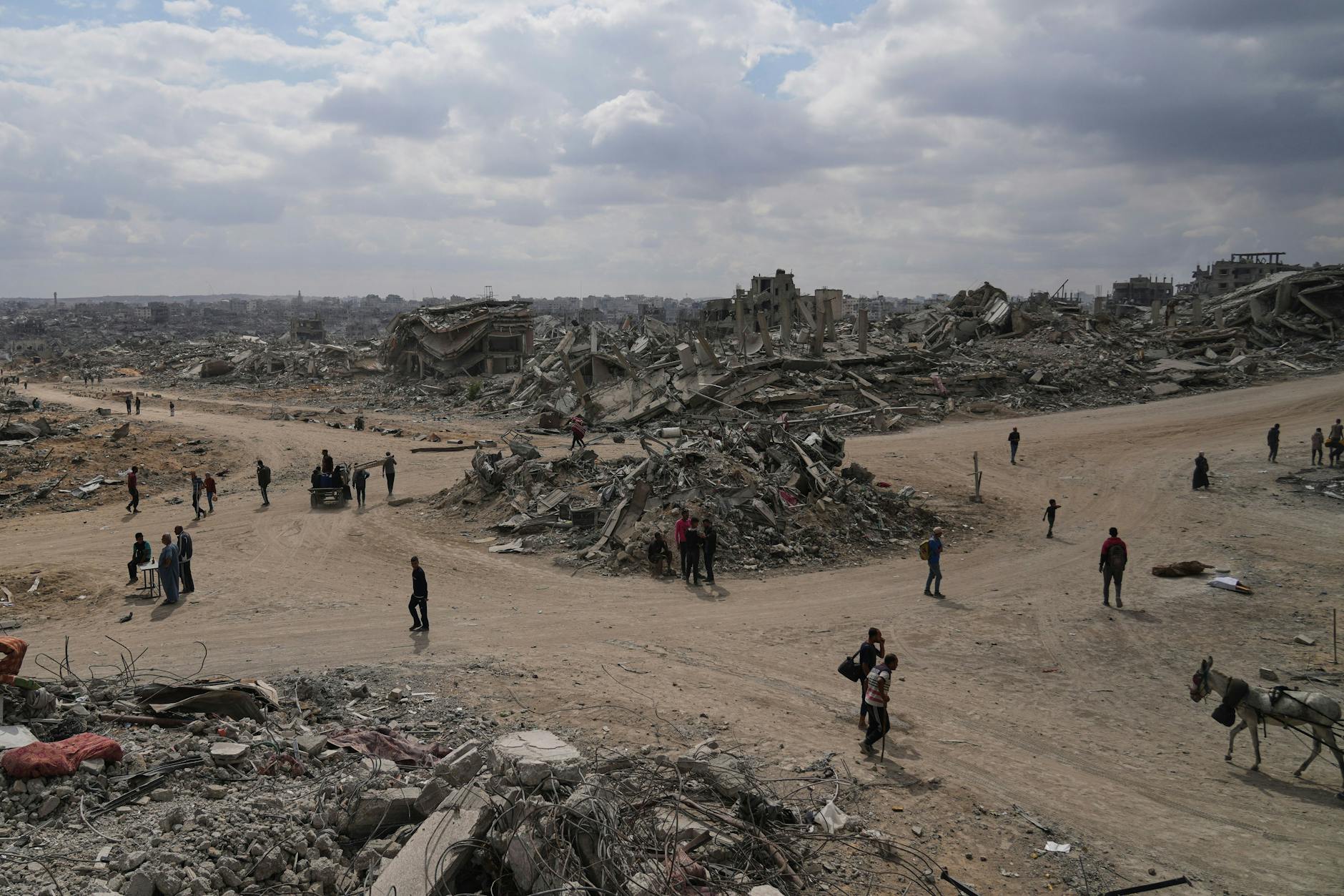 Vertriebene Palästinenser gehen zwischen zerstörten Gebäuden in der Al-Jalaa-Straße entlang