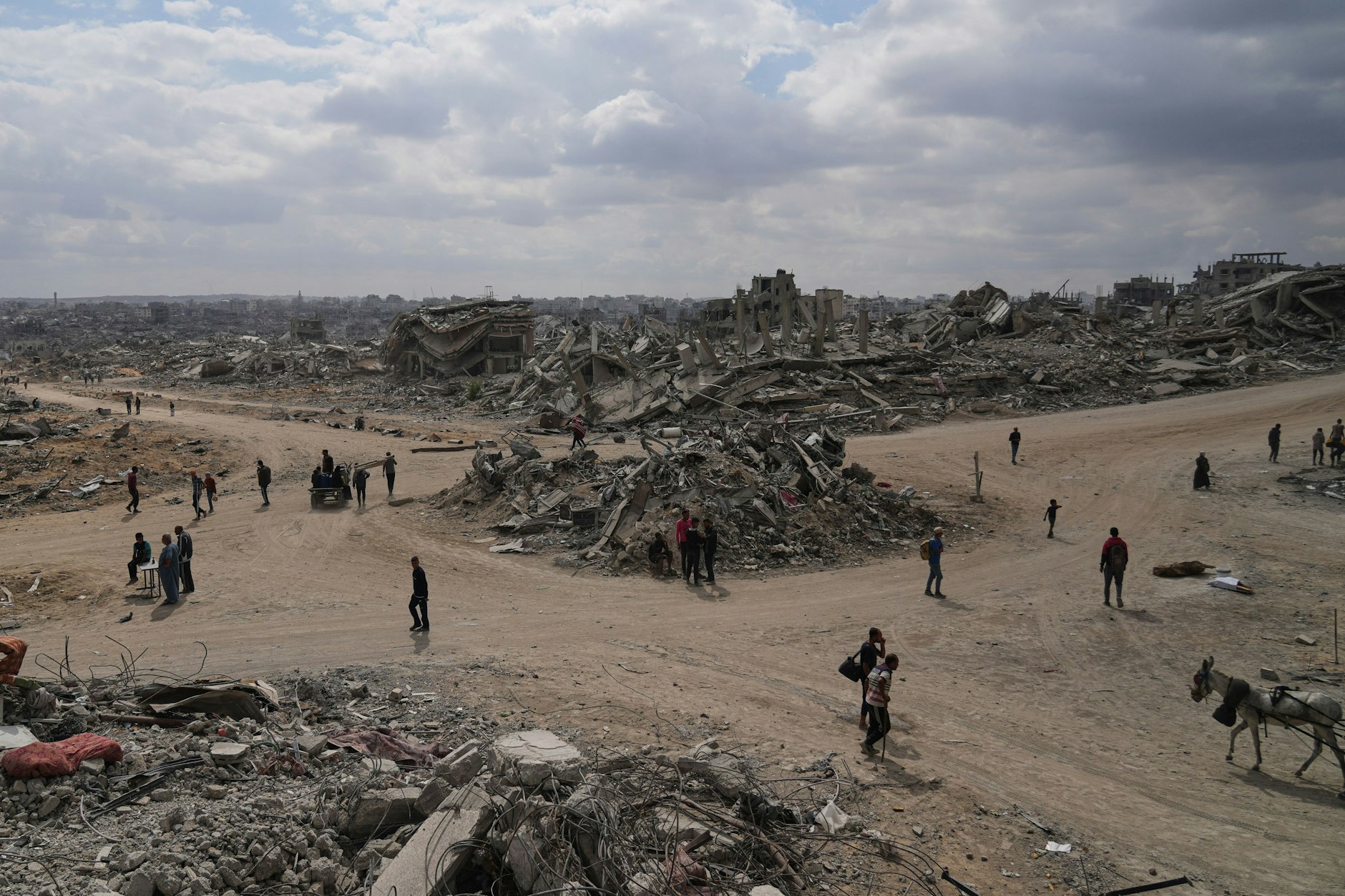 Vertriebene Palästinenser gehen zwischen zerstörten Gebäuden in der Al-Jalaa-Straße entlang