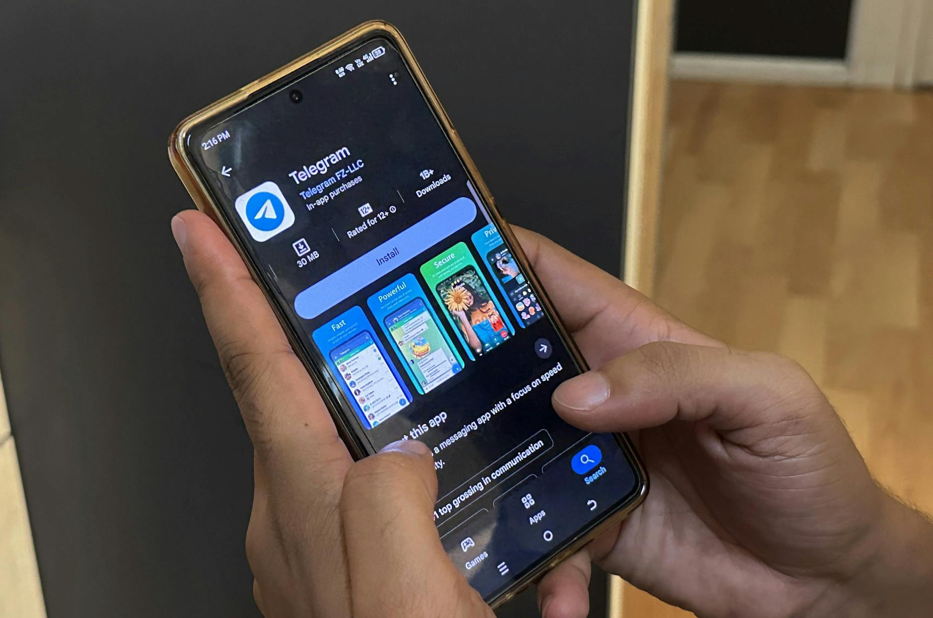 Ein Mann scrollt durch sein Mobiltelefon, um die Telegram-App zu installieren.