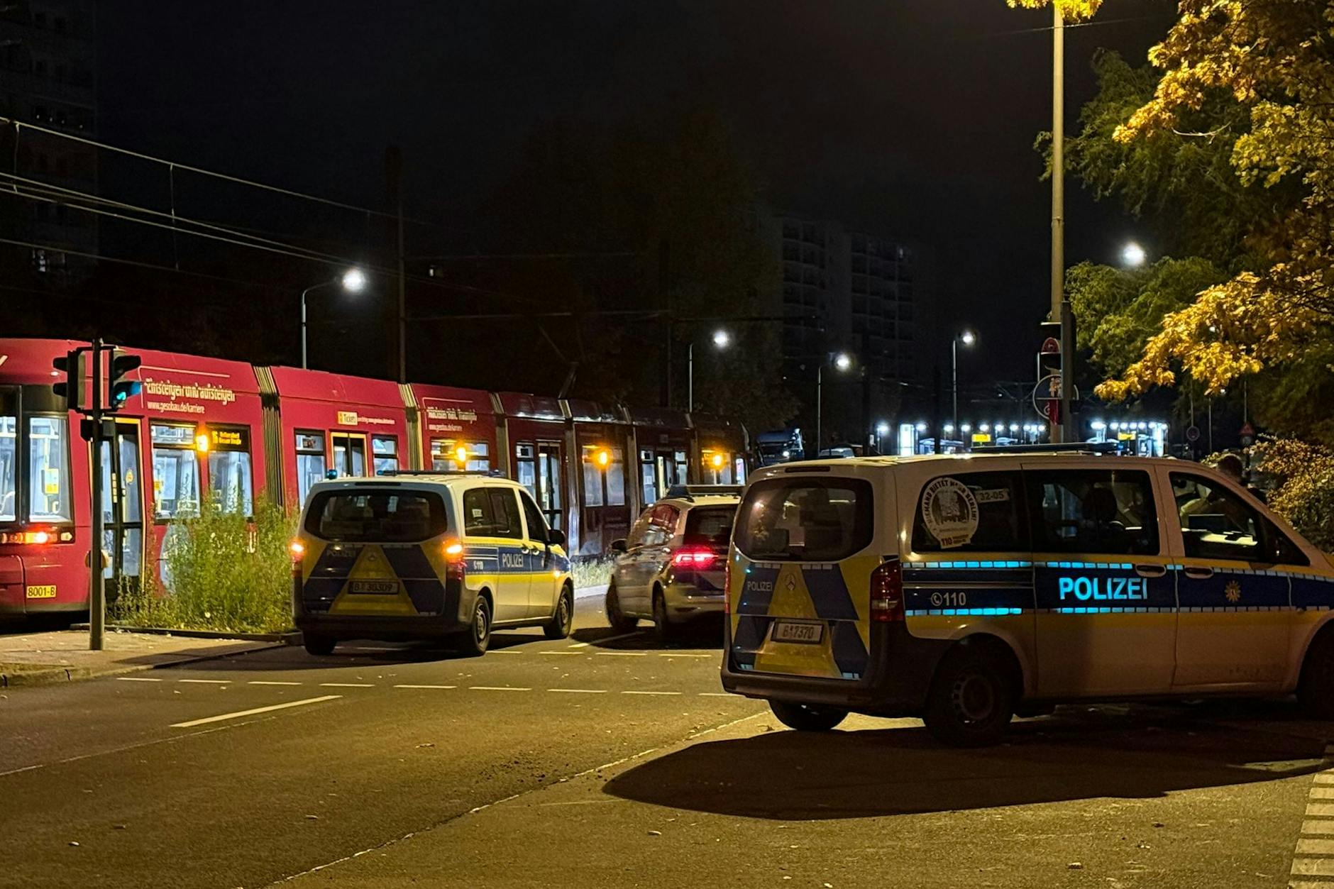 Mehrere Polizeiwagen stehen in Berlin-Marzahn vor einer BVG-Tram. Hier hatte es eine wilde Prügelei gegeben.