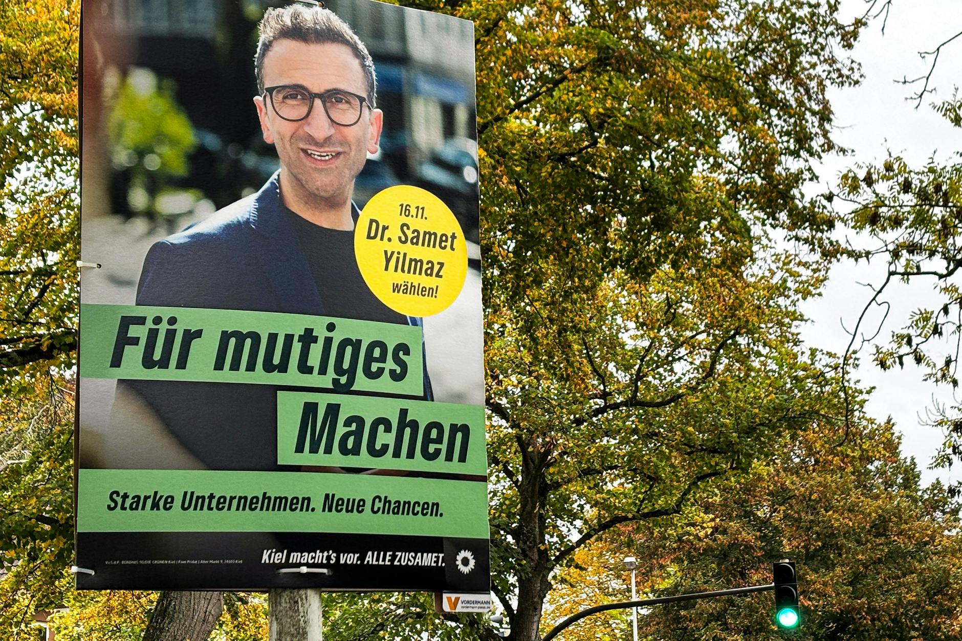 Ein Wahlplakat von Samet Yilmaz hängt an einem Laternenmast.