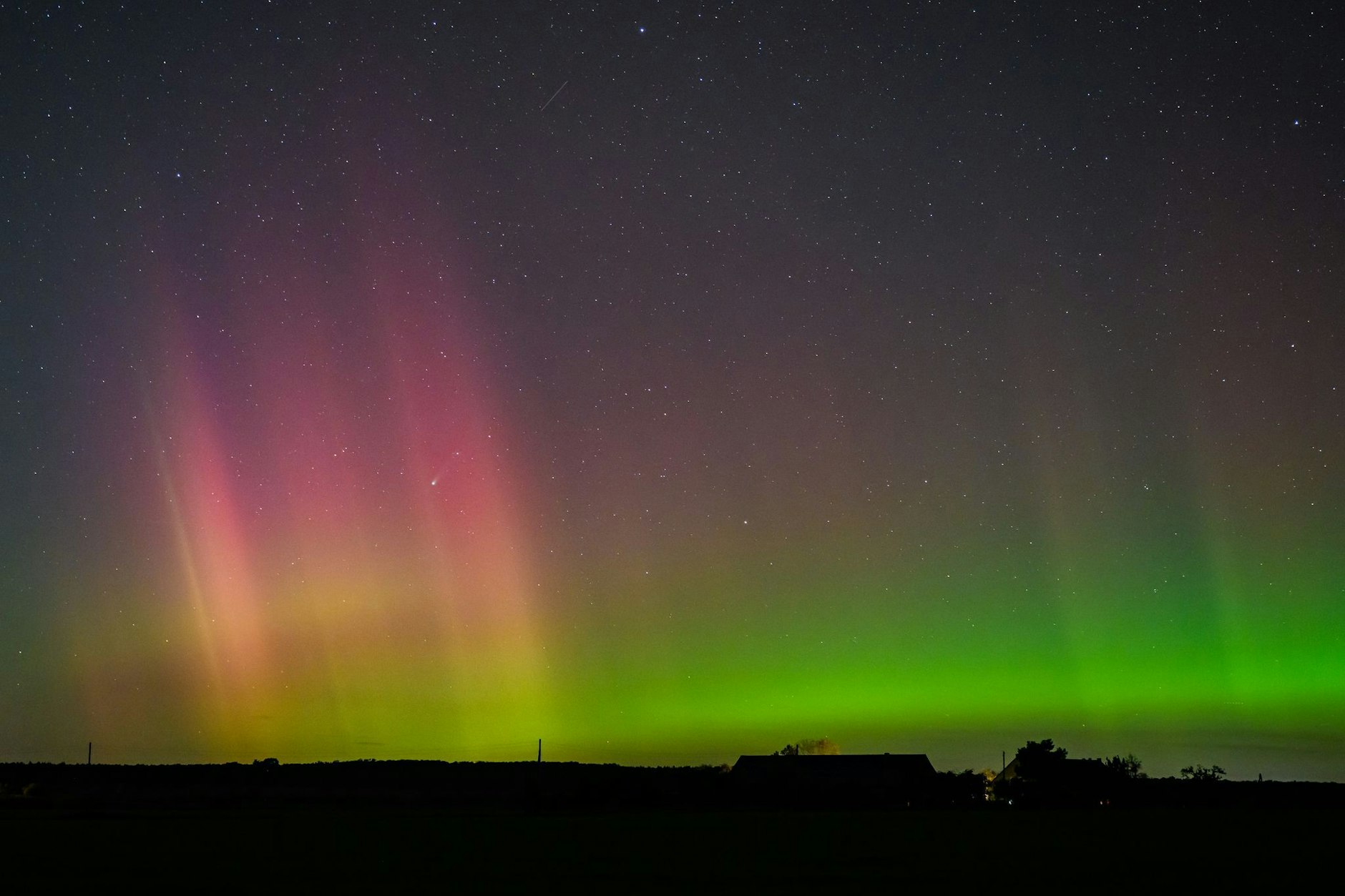 Polarlichter leuchten am Nachthimmel über der Landschaft im östlichen Brandenburg. 