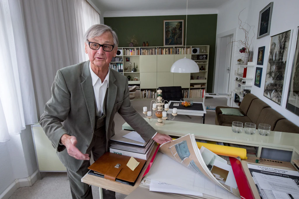 Der bekannte Möbelgestalter Rudolf Horn steht in seiner Wohnung in Leipzig in seinem Arbeitszimmer vor Möbelentwürfen der 1960er/70er Jahre. 